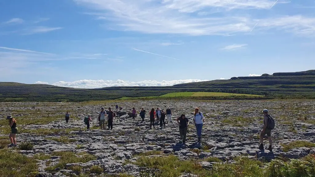 People walking on limestone pavement in the Burren